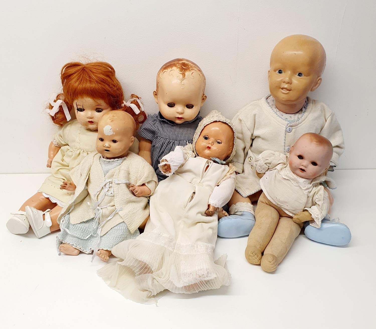 A 1940s composition baby doll, 44 cm, and five other dolls (box) Provenance: From a vast single