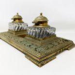 An early 20th century brass inkstand, with a pair of glass inkwells, 36 cm wide