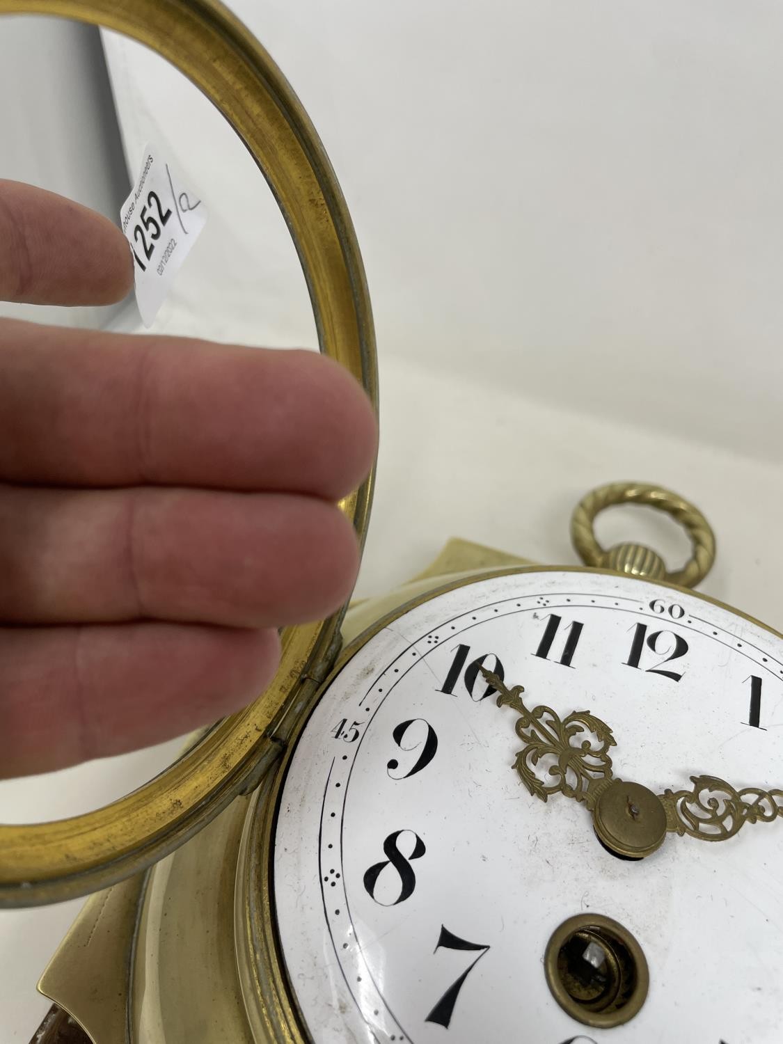 A wall clock, the 11 cm diameter enamel dial with Arabic numerals, in a brass case mounted on an oak - Image 4 of 5