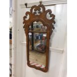 A walnut framed mirror, with scroll decoration 77 cm x 42 cm