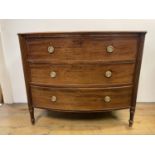 A George III mahogany bow front chest, of three drawers, flanked by reeded column supports, 88 cm