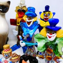 A Murano glass clown, 30 cm high, two others, a pair of pottery cats, another, assorted clown