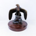 A bronze figure of an eagle, on an oak base, 26 cm high