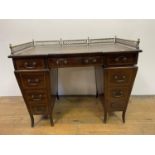 An Edwardian mahogany pedestal desk, the top with a brass gallery above nine drawers, with satinwood