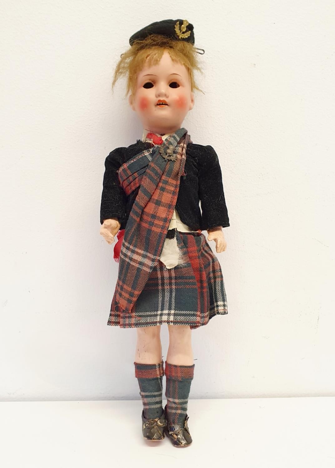 An Armand Marseille German bisque headed doll, No 390, with a composite body, in a Scottish