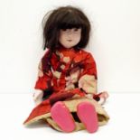 A Japanese style bisque headed doll, with a cloth and bisque body, in a traditional outfit, 64 cm