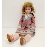 A German bisque headed doll, with a jointed composite body, with millefiori glass closing eyes, in a