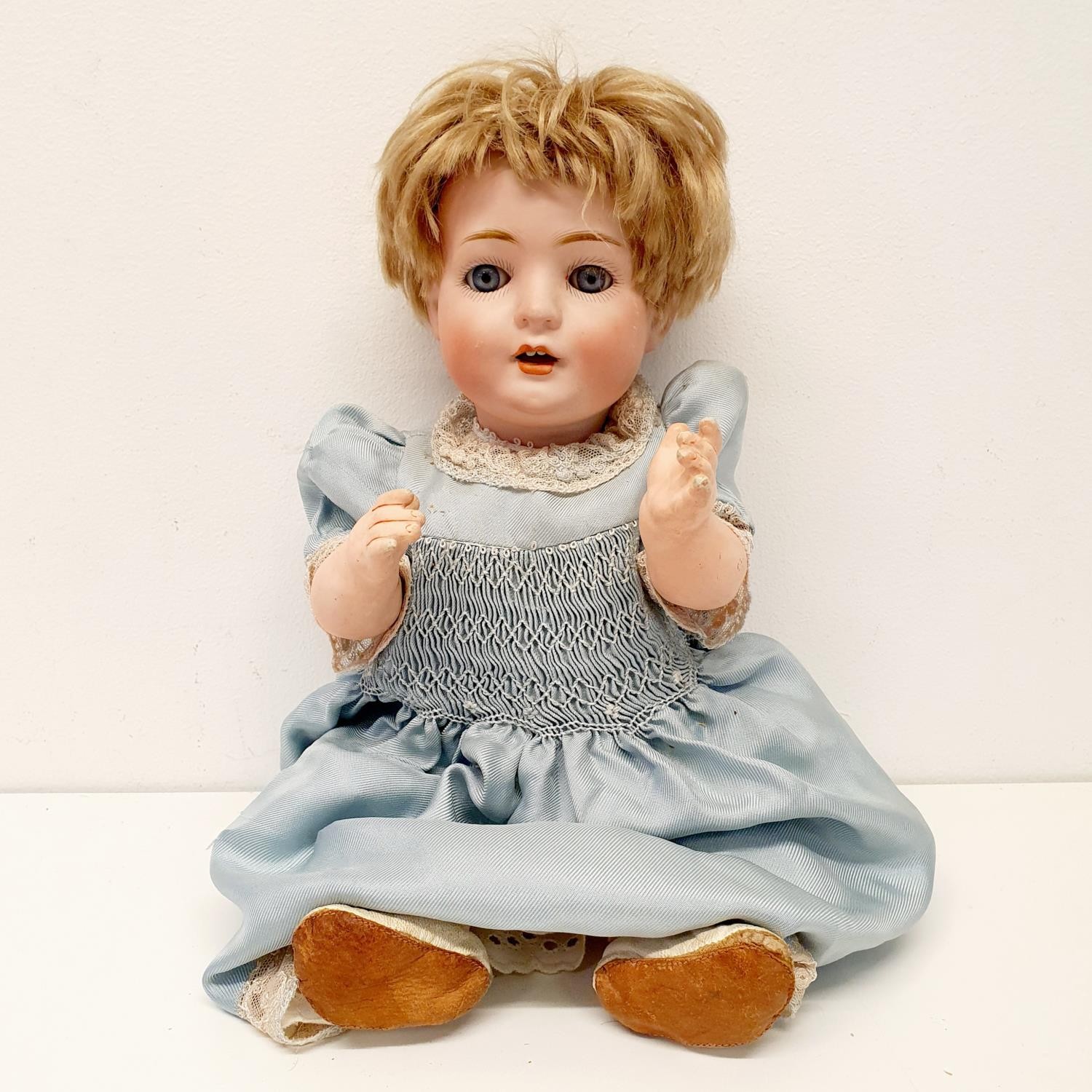 A Bruno Schmidt German bisque headed doll, with a composite body and millefiori glass eyes, 34 cm
