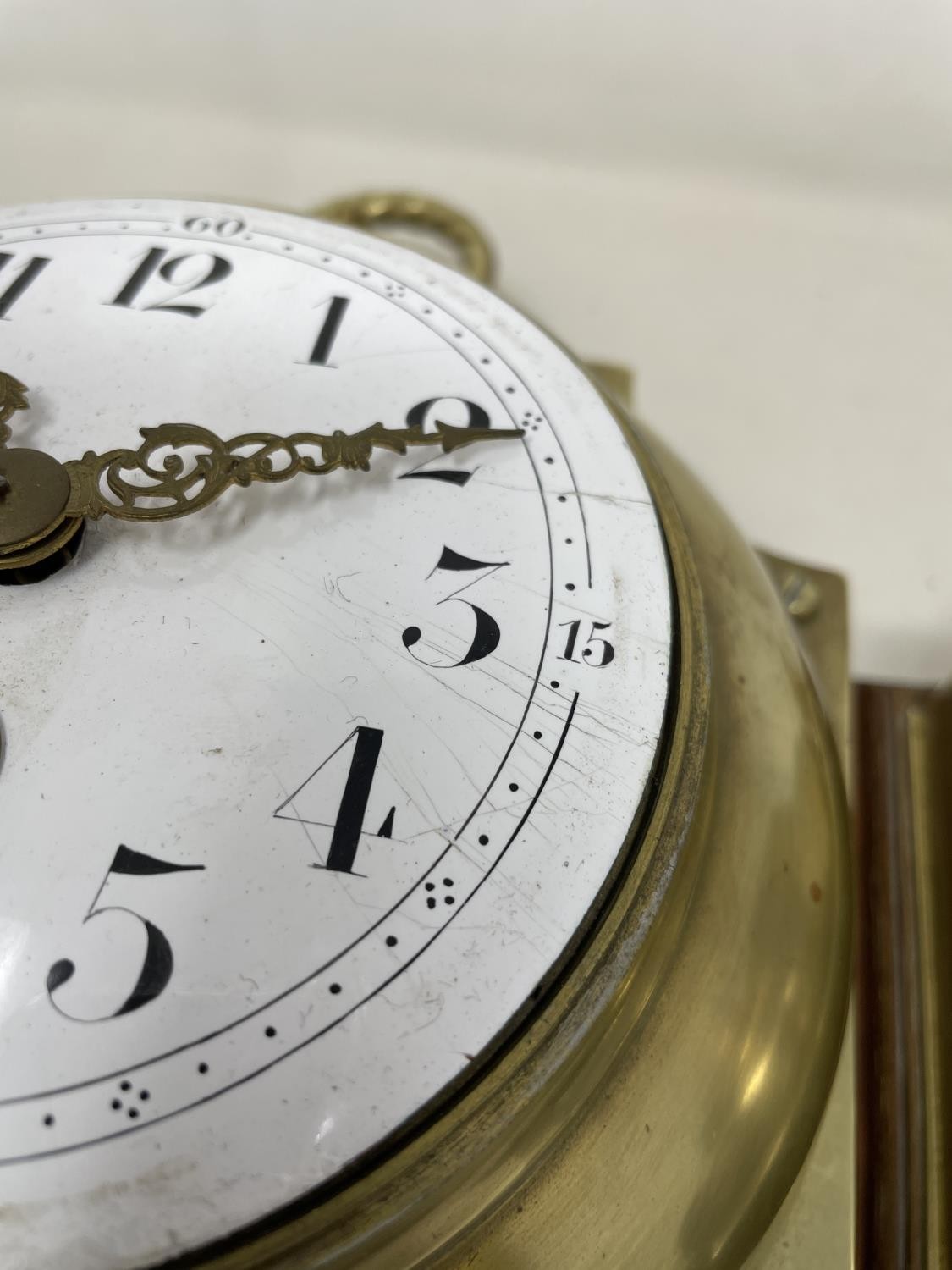 A wall clock, the 11 cm diameter enamel dial with Arabic numerals, in a brass case mounted on an oak - Image 3 of 5