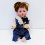 A J D Kestner German bisque headed doll, with a composite body with millefiori closing glass eyes,