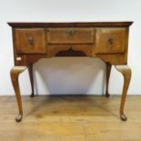 A walnut lowboy, having three drawers, all raised on cabriole legs to pad feet, 91 cm wide In need