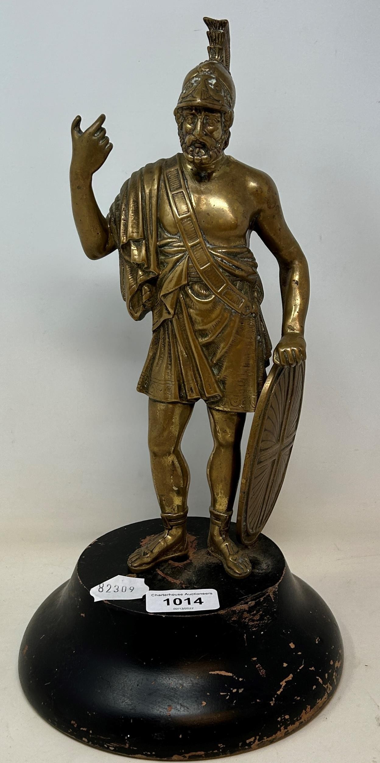 A brass figure of a Roman centurion, 30 cm high, on a later ebonised base Some wear to the figure,