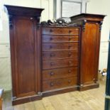 A 19th century mahogany wardrobe, with a central chest of seven drawers, flanked by two cupboard