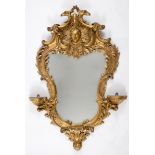 An 18th century style rococo carved giltwood wall mirror, of shaped cartouche form, 113 x 74 cm This