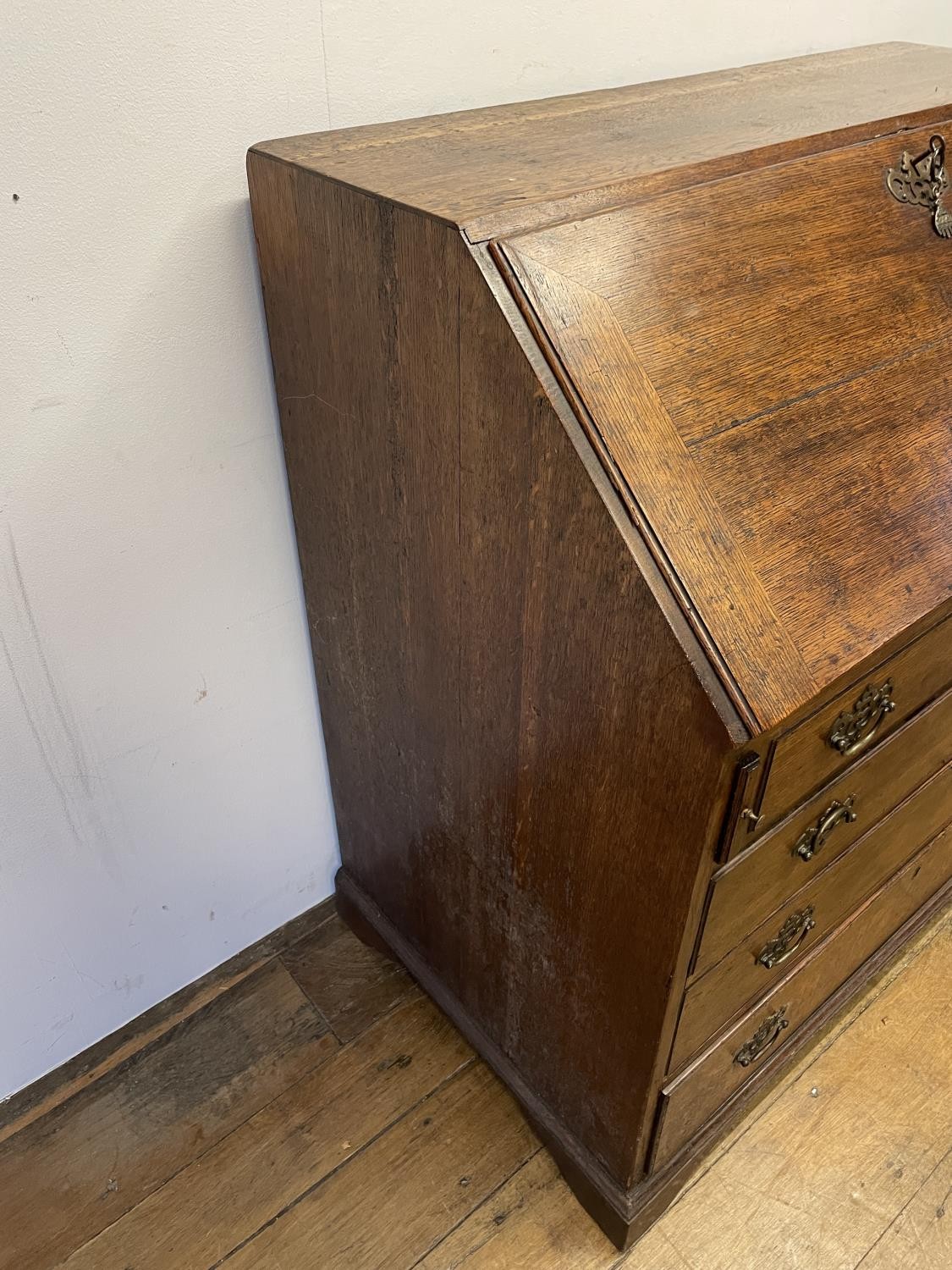 A George III oak bureau, the fall front to reveal a fitted interior, above four graduated drawers, - Image 2 of 9