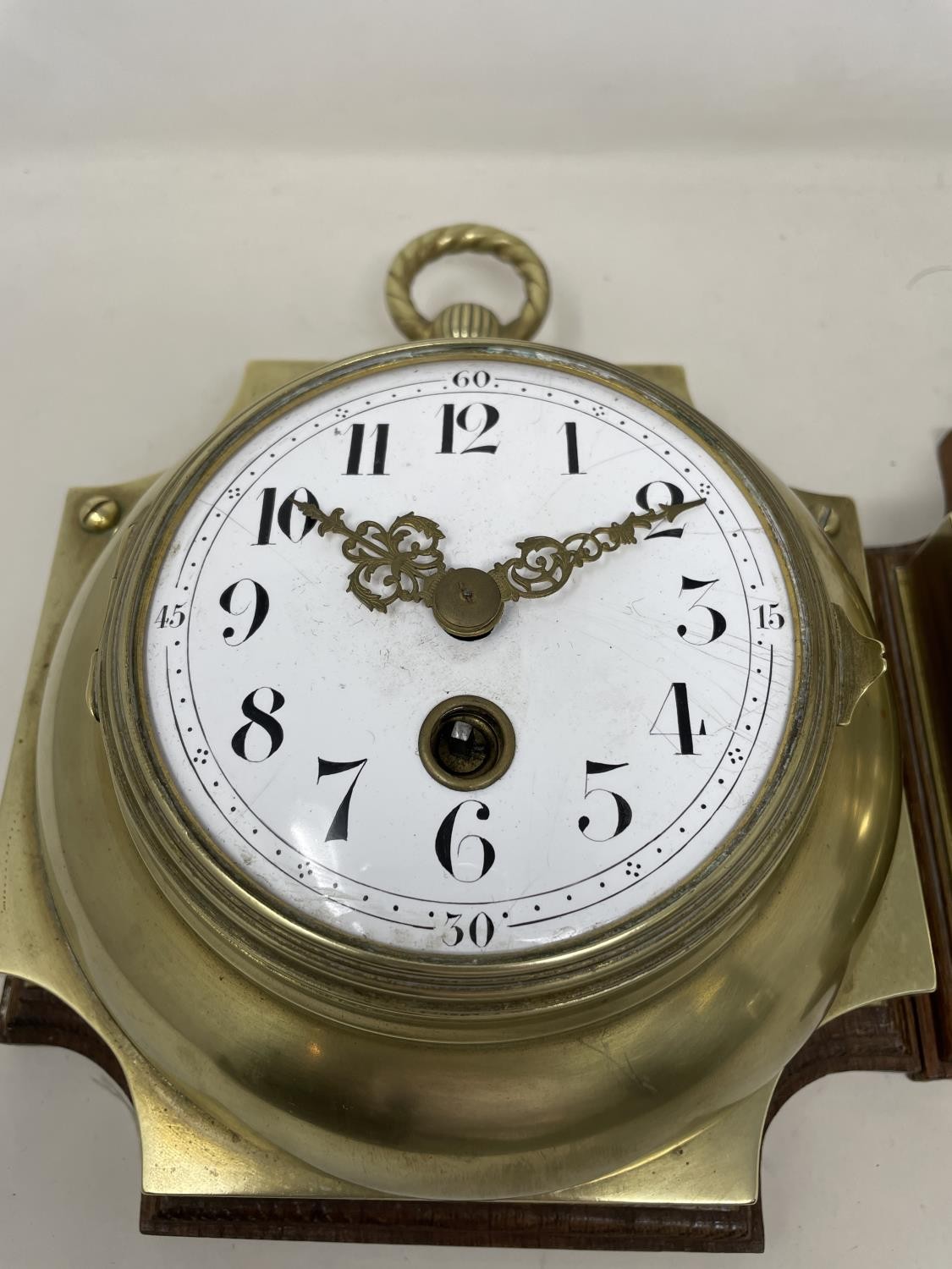 A wall clock, the 11 cm diameter enamel dial with Arabic numerals, in a brass case mounted on an oak - Image 2 of 5