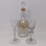 A double cotton twist glass, another similar and a decanter and stopper with gilt decoration in