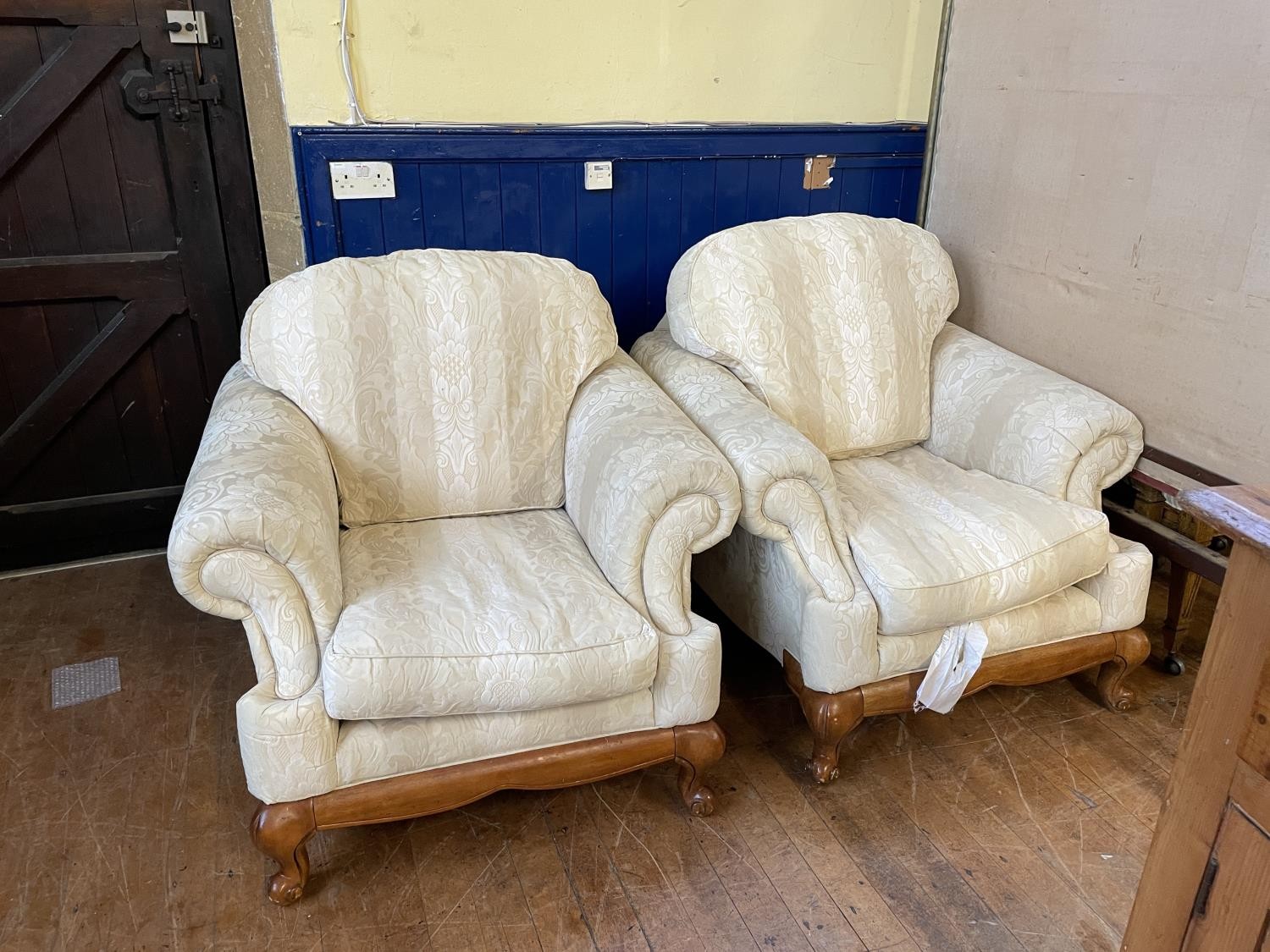 A cream three piece suite, comprising three seater sofa and two armchairs, a cream drop end sofa,