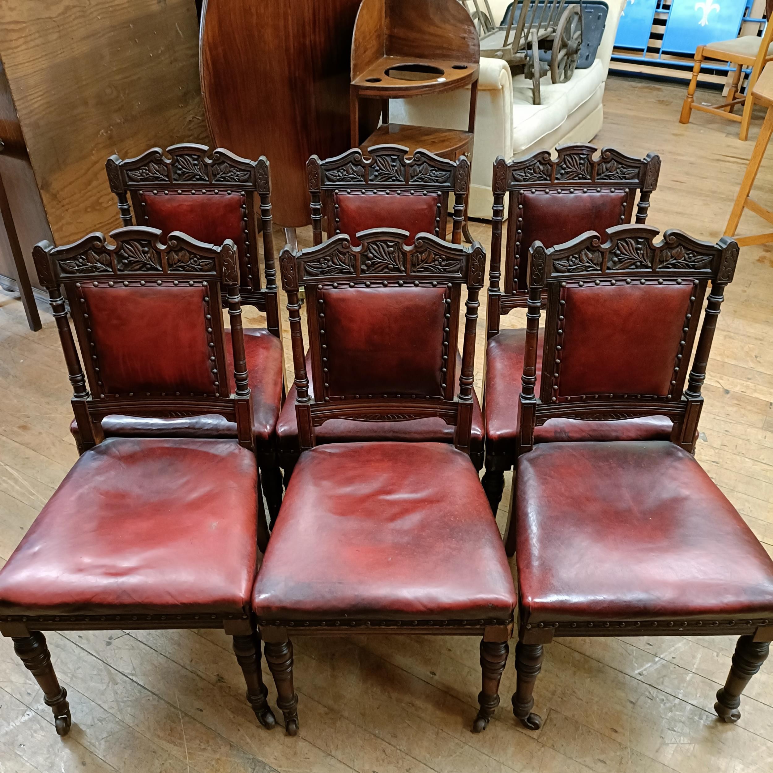 A set of six late 19th century carved walnut dining chairs, with leather padded backs and seats (6)