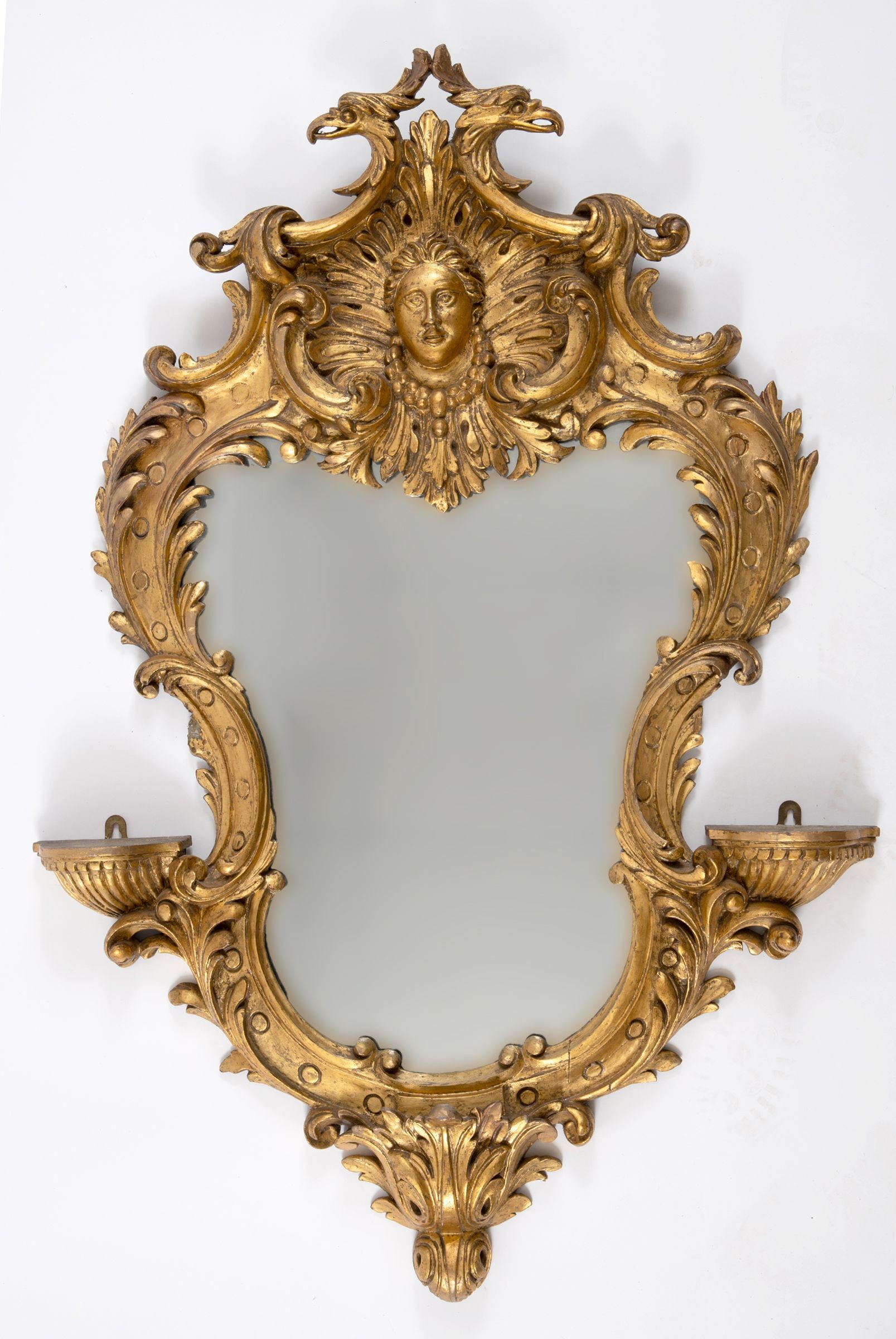 An 18th century style rococo carved giltwood wall mirror, of shaped cartouche form, 113 x 74 cm This