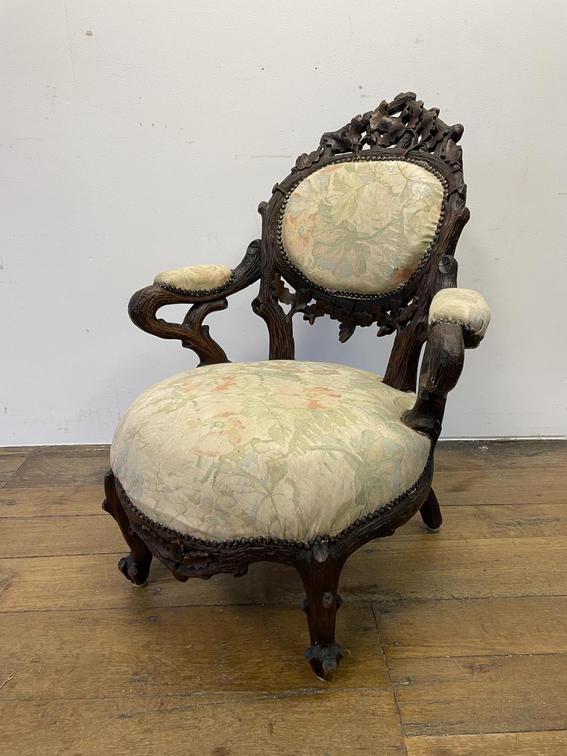 A Black Forest style carved oak armchair