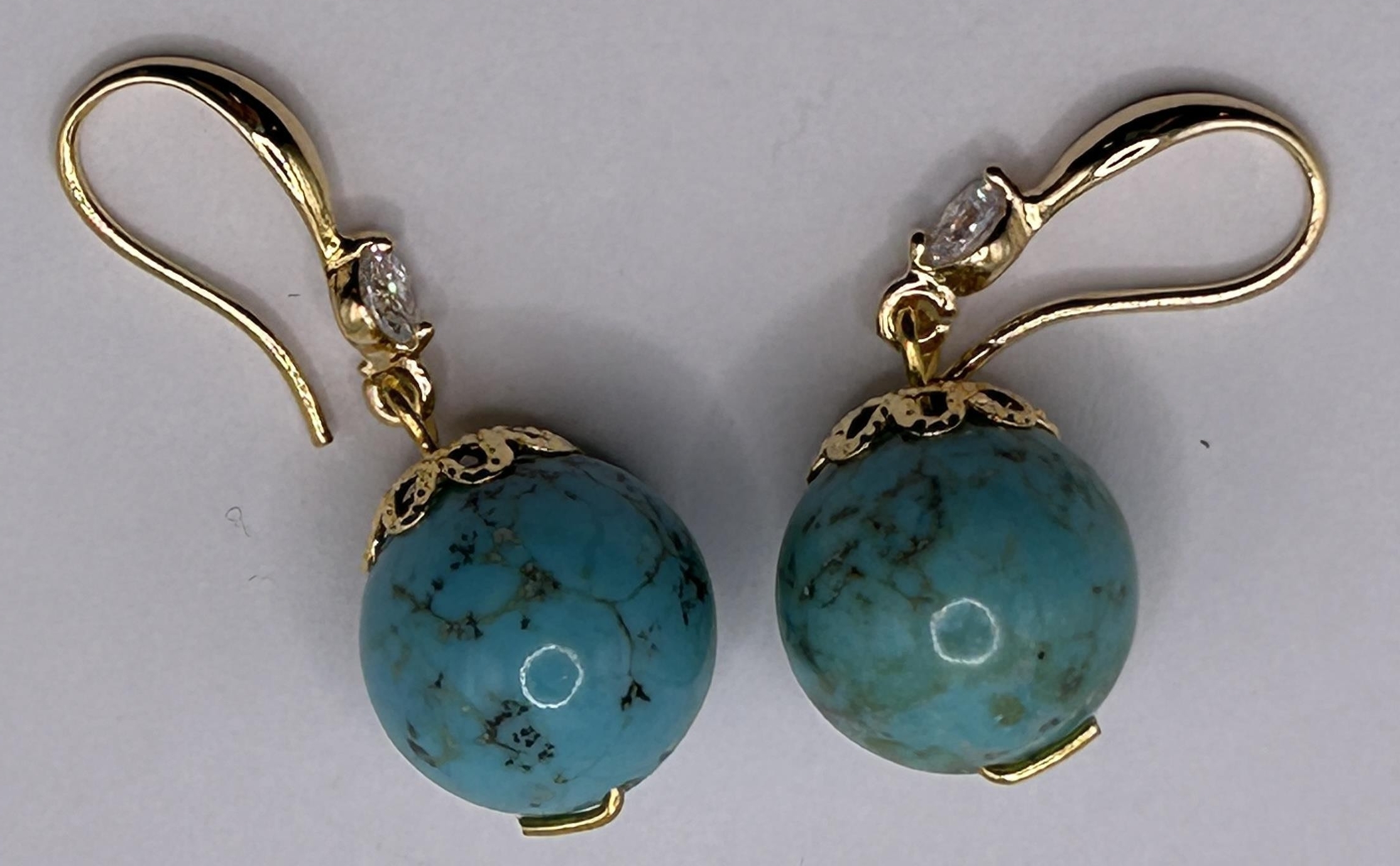 A pair of turquoise and white stone earrings