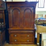 A 19th century mahogany linen press, the top having two cupboard doors, on a base with three