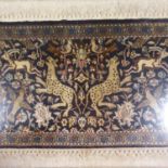 A Persian silk rug, multiple borders, the centre decorated animals, birds and flowers, framed and