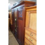 An early 20th century walnut triple wardrobe, with a central mirrored door, 185 cm wide