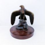 A bronze figure of an eagle, on an oak base, 26 cm high, and an amusing novelty teapot, Humpty