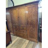 An early 20th century mahogany wardrobe, the centre with two cupboard doors, above two long and