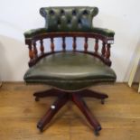 A modern mahogany framed and green button back leather desk chair