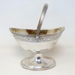 A Victorian silver sugar basket, with a swing handle and engraved decoration, on an oval pedestal