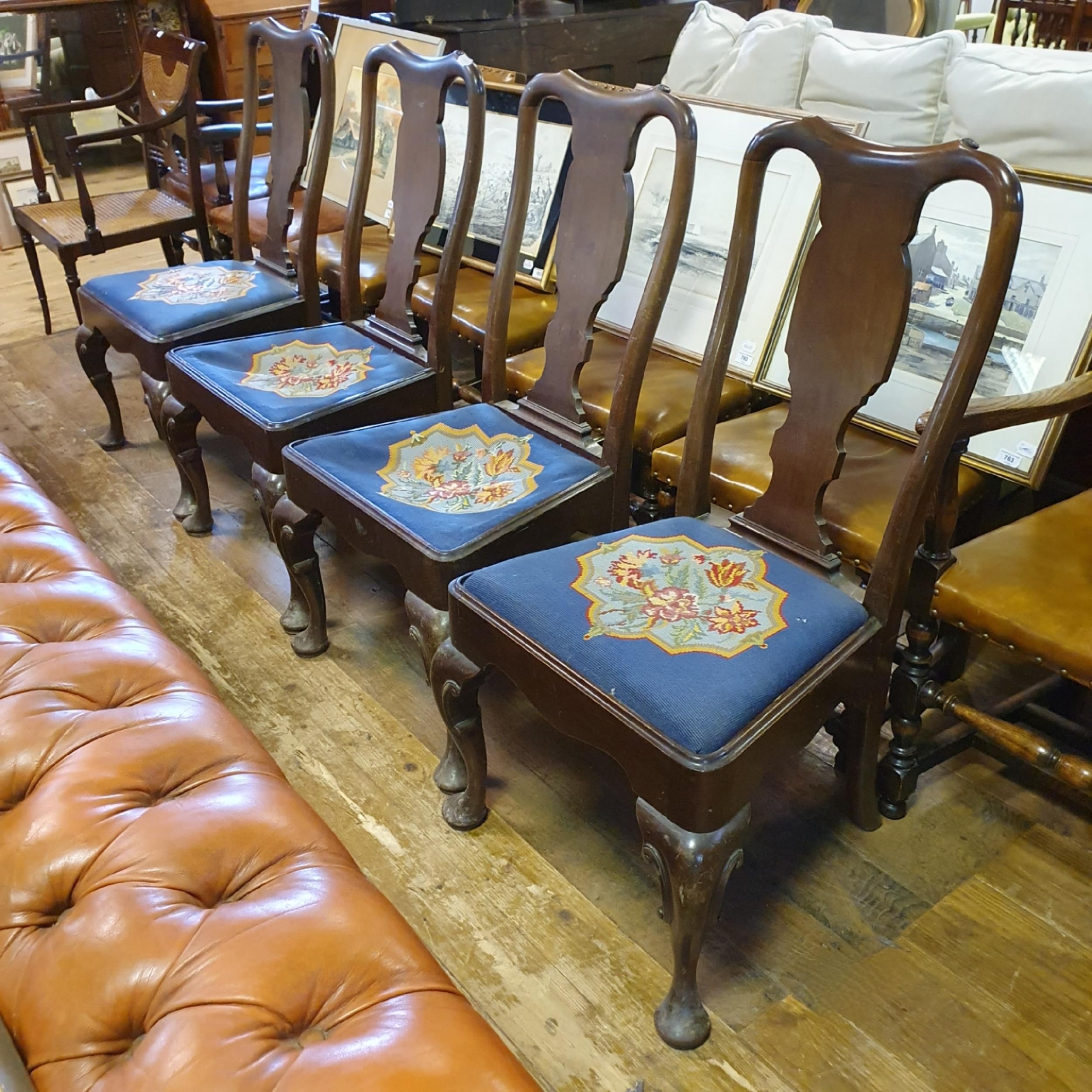 A set of four Queen Anne style walnut framed dining chairs, with drop in tapestry padded seats (4)