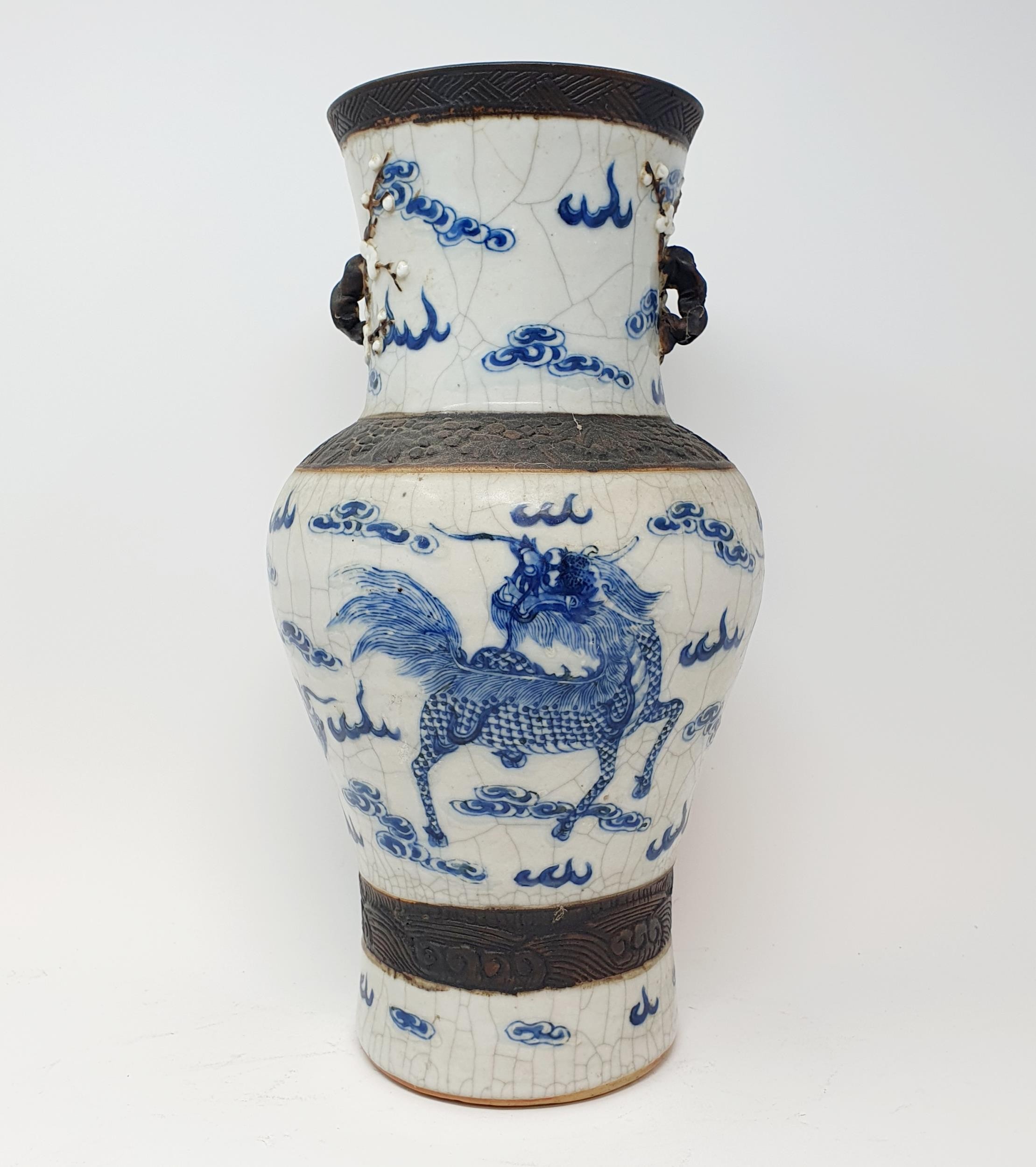 A Chinese underglazed blue and white vase, with a crackled glaze, decorated mythical beasts, 38 cm