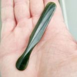 A small dark green stone paddle, 9 cm wide