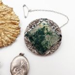A silver coloured metal, white and green stone brooch, and two other brooches