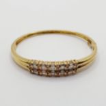 An 18ct gold and diamond bangle 6.5 cm wide, all in 19.2 g