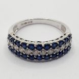 An 18ct white gold, sapphire and diamond half eternity ring, ring size M