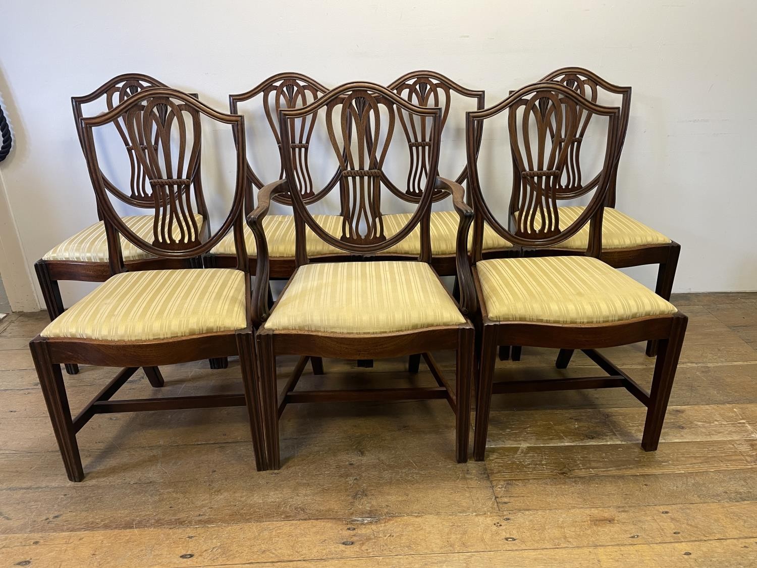 A set of seven George III style mahogany shield back dining chairs (6+1)