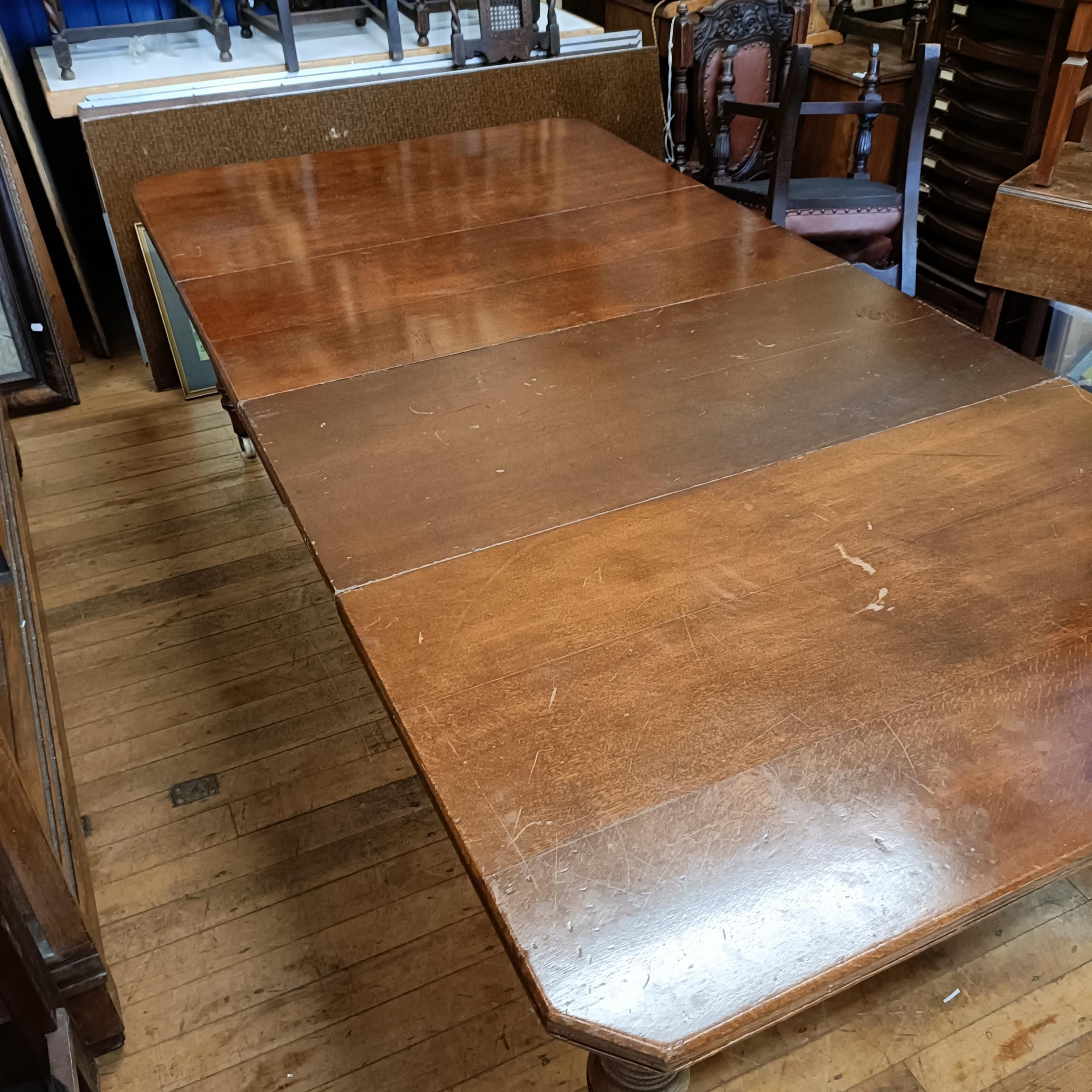 An early 20th century oak extending dining table, with two extra leaves, the top 124 cm wide The - Image 4 of 5