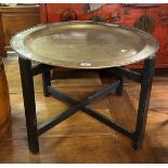 A brass tray top table, decorated in the Japanese manner, on an ebonised base