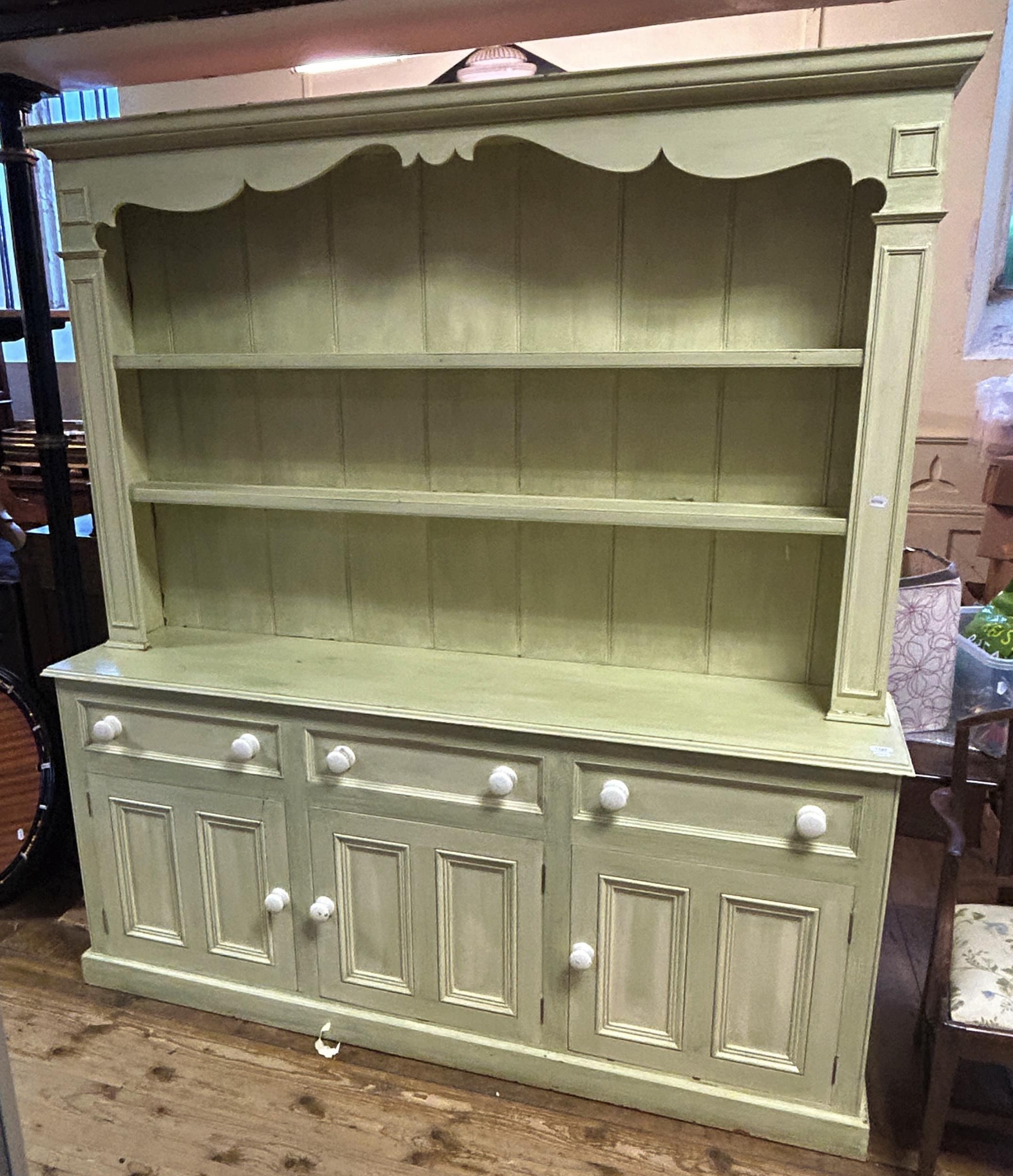 A painted dresser, with a three tier plate rack above a base with four drawers and four cupboard