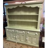 A painted dresser, with a three tier plate rack above a base with four drawers and four cupboard