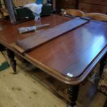 A mahogany extending dining table, on turned tapering legs, the top 130 cm x 120 cm, with an extra