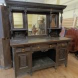 A large oak dresser, with a mirrored back on a base with three drawers and two cupboard doors, 186