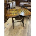 A Victorian walnut game/work table, 62 cm wide Has been restored, top has cracked and lifted