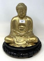 A gilt bronze buddha, on a carved wooden stand, 36 cm high (2)