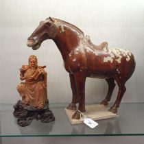 A Tang style stoneware horse and a carved stone figure (2) Horse: losses are man made and