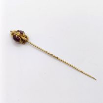 A late 19th/early 20th century yellow metal and red stone stick pin Provenance: From a single